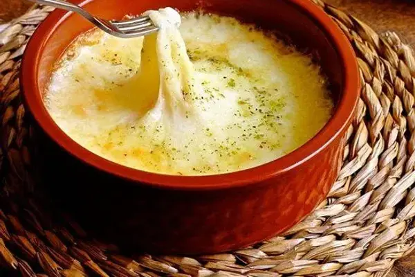 Provolone al horno fundido en una cazuela de barro, con orégano por encima